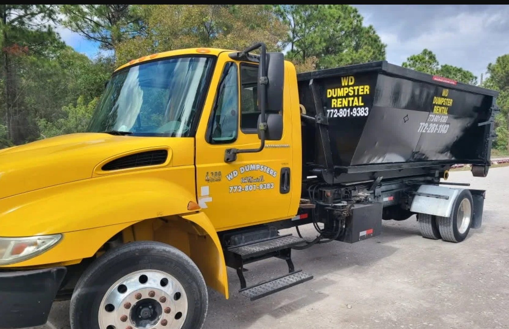 WD Dumpsters Rental roll-off truck delivering a dumpster in Port St. Lucie